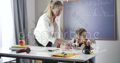 开朗的白种人女孩用红色铅笔在练习本上写字，抬头看着成人老师。 可爱的女学生